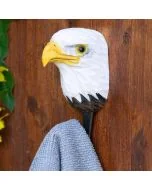 Decoratieve wandhaak met Amerikaanse zeearend van hout en metaal tegen een rustieke houten achtergrond