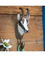 Decoratieve wandhaak met houten gemskop van Wildlife Garden, gemonteerd op ruwe houten planken met een groene band aan de haak.
