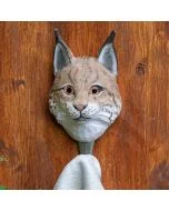 Houten kledinghaak in de vorm van een lynx van Wildlife Garden, bevestigd aan een houten wand met een lichte handdoek aan de haak.