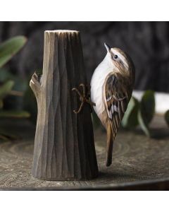 De DecoBird Boomkruiper is afgebeeld in zijn typische pose, kruipend tegen een boomstam.