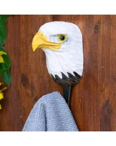 Decoratieve wandhaak met Amerikaanse zeearend van hout en metaal tegen een rustieke houten achtergrond