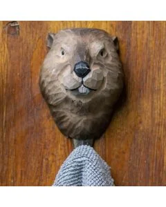 Decoratieve wandhaak met houten beverkop van Wildlife Garden, bevestigd op een houten ondergrond met een grijze handdoek eraan.
