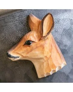 Beschilderde houten reekop als magneet op een donkergrijze metalen wand, met grote oren, zwarte oogpartij en warmbruine vachttekening.